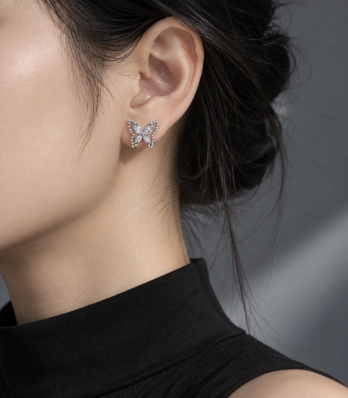 JIMIKI Silver-Tone Crystal Butterfly Stud Earrings in Silver / Clear, editorial model view