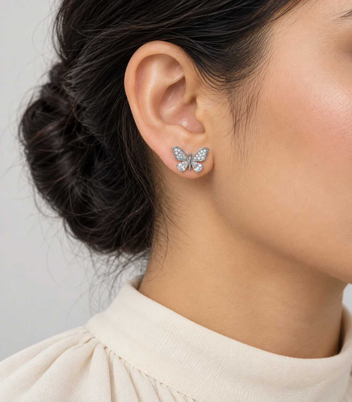 JIMIKI Silver-Tone Crystal Butterfly Stud Earrings in Silver / Clear, model wearing view