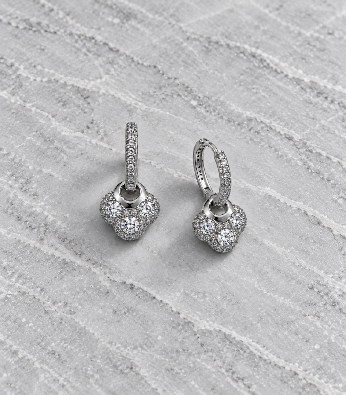 JIMIKI Crystal Clover Charm Hoop Earring Pair in Silver Tone, editorial flat lay #color_silver tone
