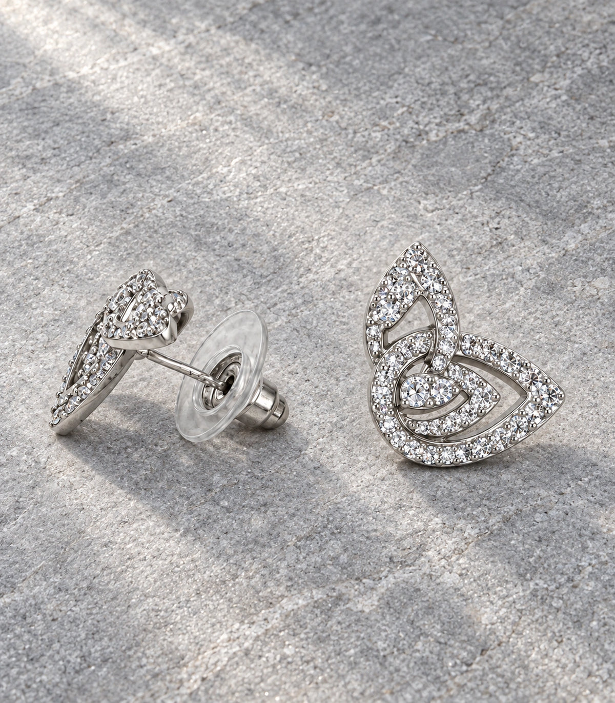 JIMIKI Crystal Open Swirl Stud Earring Pair in Silver tone, editorial flat lay #color_silver tone