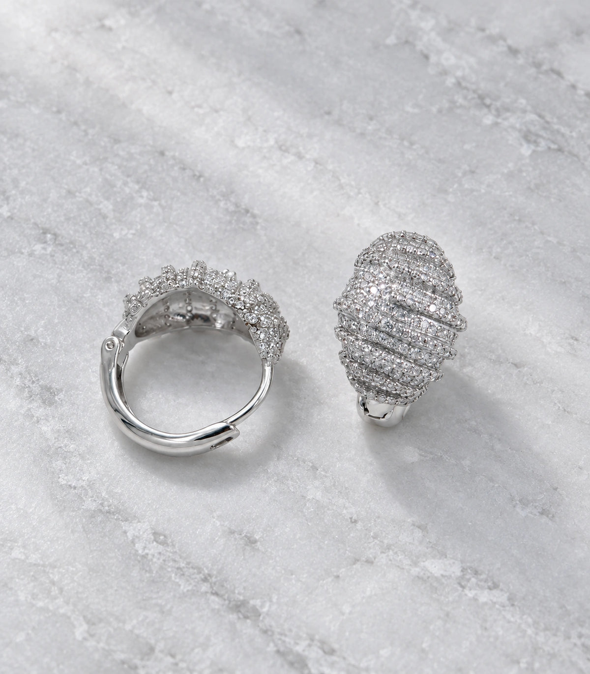 JIMIKI Crystal Ribbed Dome Huggie Earrings in Silver / Clear, editorial flat lay #color_silver / clear