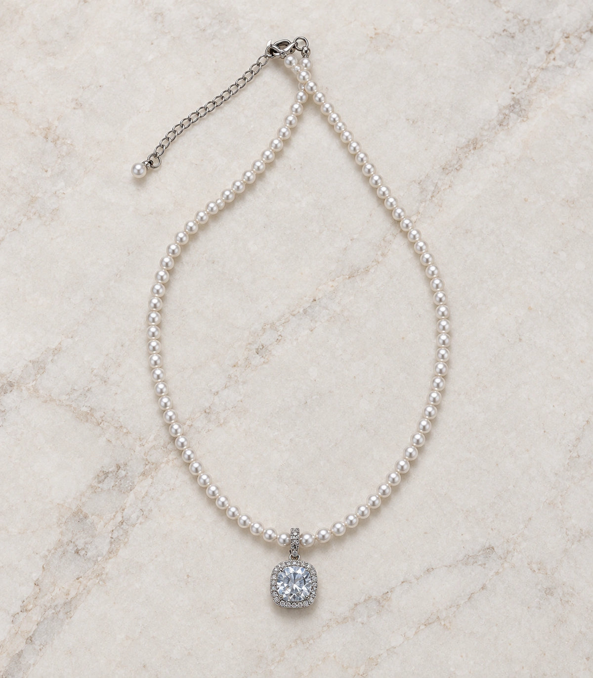 JIMIKI Silver-Tone Cushion Crystal Halo Pearl Necklace in Silver-tone / clear / white, arranged in an editorial flat lay
