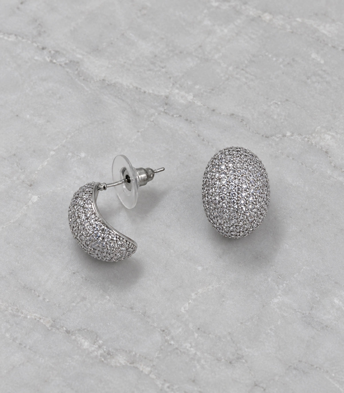 JIMIKI Domed Pave Oval Stud Earring Pair in Silver Tone, editorial flat lay #color_silver tone