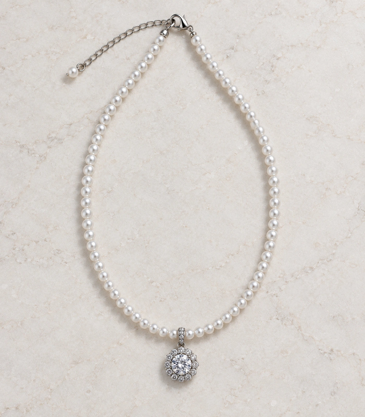 JIMIKI Silver-Tone Floral Cluster Crystal Pearl Necklace in Silver-tone / clear / white, arranged in an editorial flat lay