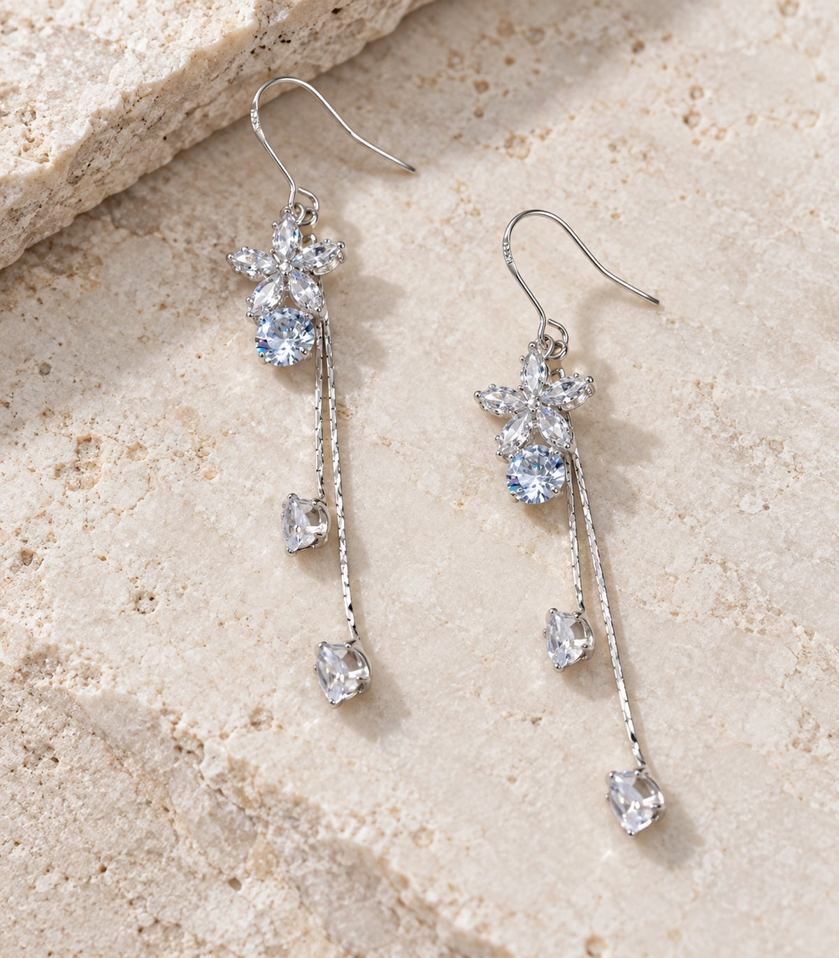JIMIKI Silver Tone Flower Round Crystal Twin Drop Earring Pair in Silver-tone, editorial flat lay