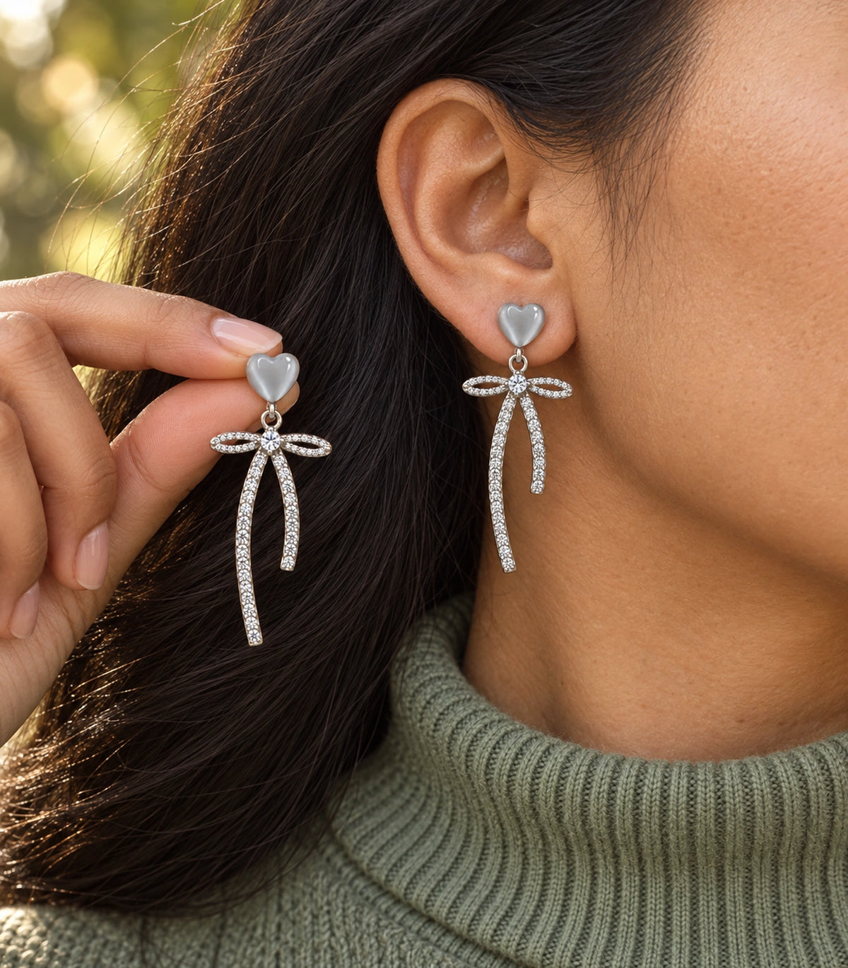 JIMIKI Heart Crystal Ribbon Bow Drop Earring Pair in Silver-tone / Grey, editorial model view #color_silver-tone / grey