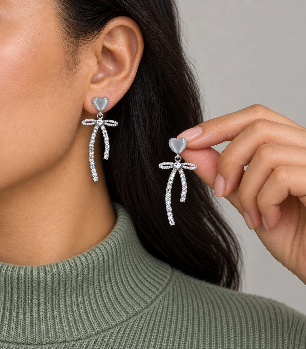 JIMIKI Heart Crystal Ribbon Bow Drop Earring Pair in Silver-tone / Grey, model wearing view #color_silver-tone / grey