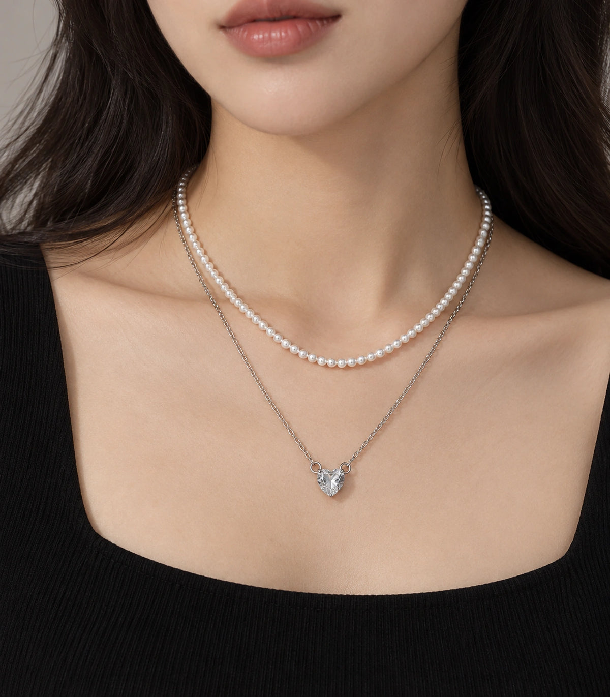 JIMIKI Silver-Tone Heart Layered Pearl Necklace Set in Silver-tone / clear / white, worn with a simple outfit