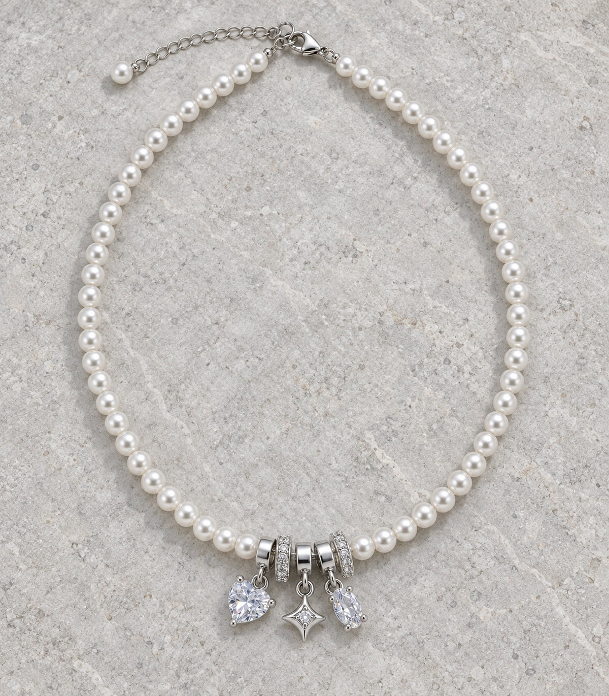 JIMIKI Silver Tone Heart Star Crystal Charm Pearl Necklace in Silver / White, editorial flat lay