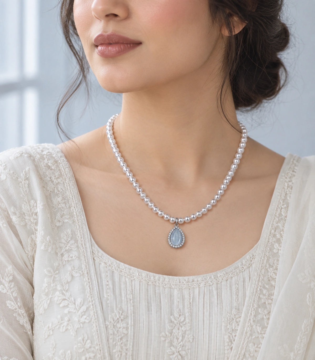 JIMIKI Silver-Tone Icy Blue Teardrop Pearl Necklace in Silver-tone / icy blue, styled on a model in an editorial setting