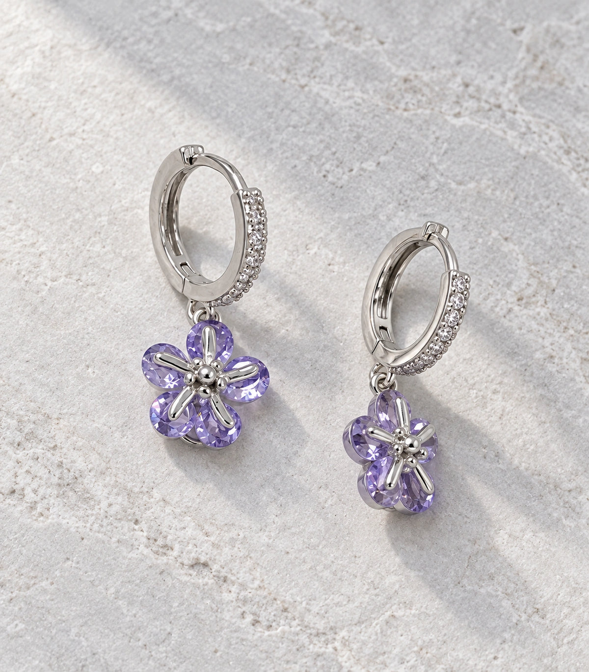 JIMIKI Silver-Tone Lavender Crystal Five-Petal Flower Huggie Earrings in Silver / Lavender, editorial flat lay