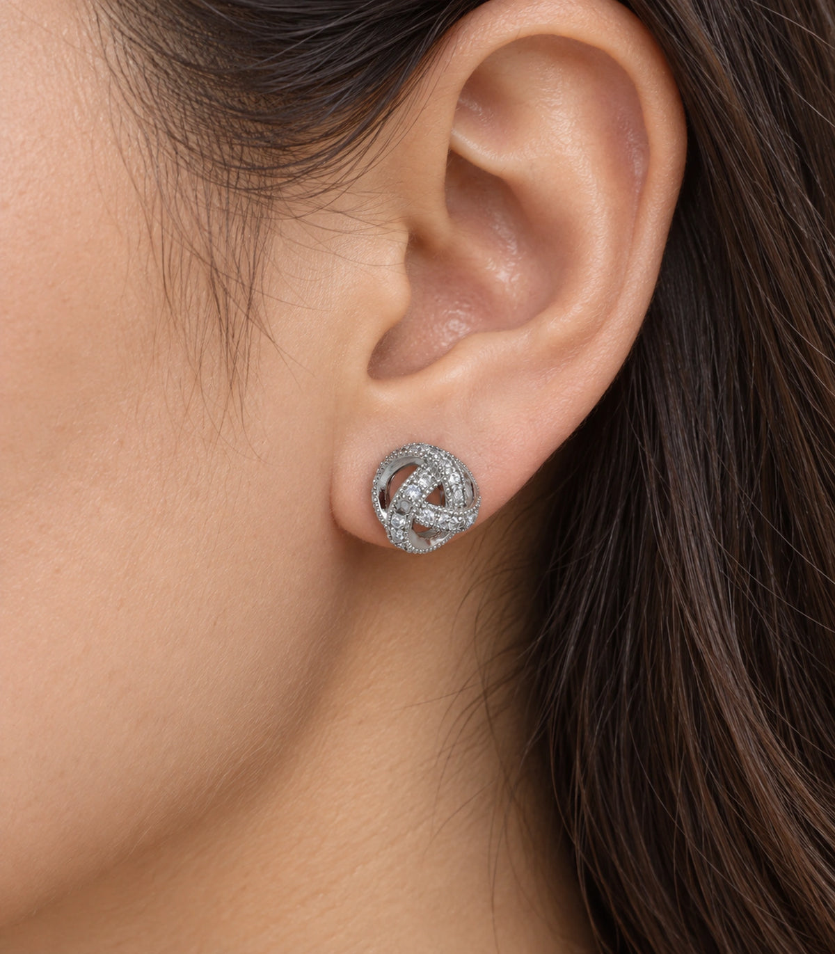 JIMIKI Silver-Tone Pavé Interwoven Knot Stud Earrings in Silver / Clear, close-up detail