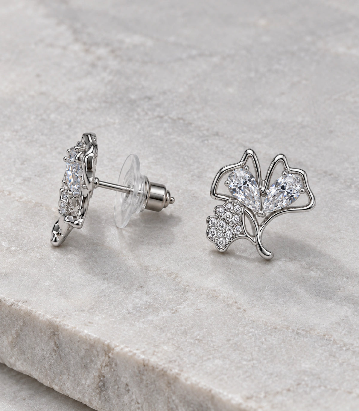 JIMIKI Pear Crystal Open Leaf Stud Earring Pair in Silver Tone, editorial flat lay #color_silver tone