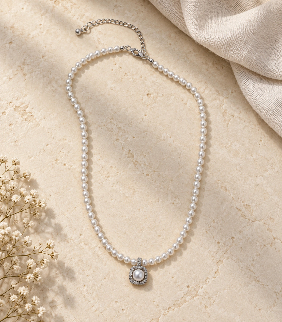 JIMIKI Silver-Tone Pearl Halo Pendant Necklace in Silver-tone, arranged in an editorial flat lay