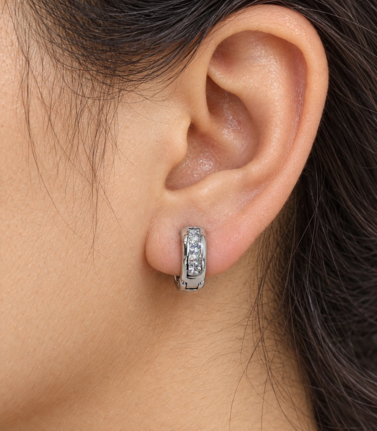 JIMIKI Silver Rectangular Crystal Channel Huggie Hoop Earrings, worn closeup showing front details #color_silver