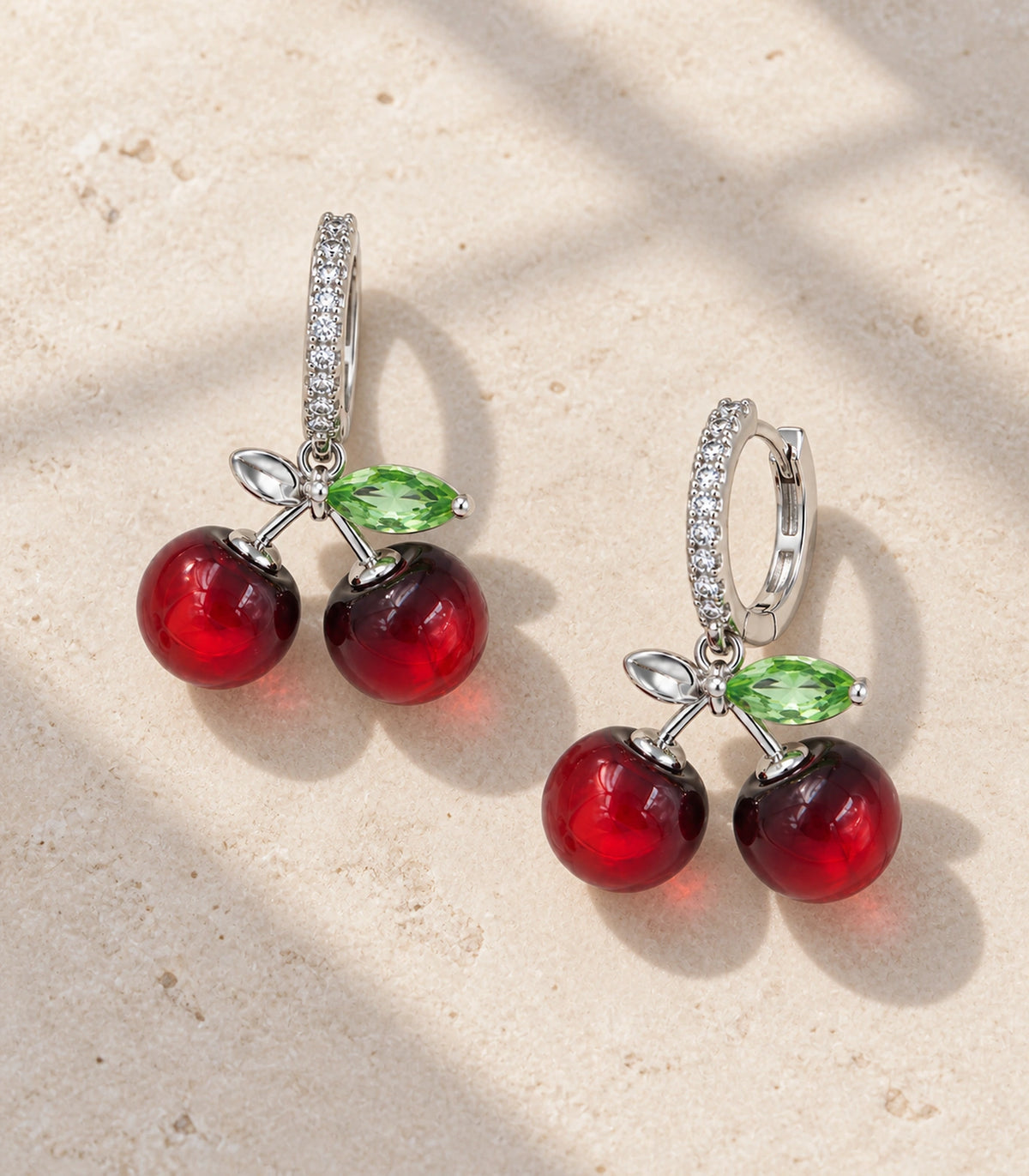 JIMIKI Cherry Crystal Leaf Hoop Earring Pair in Silver-tone / Red / Green, editorial flat lay #color_silver-tone / red / green