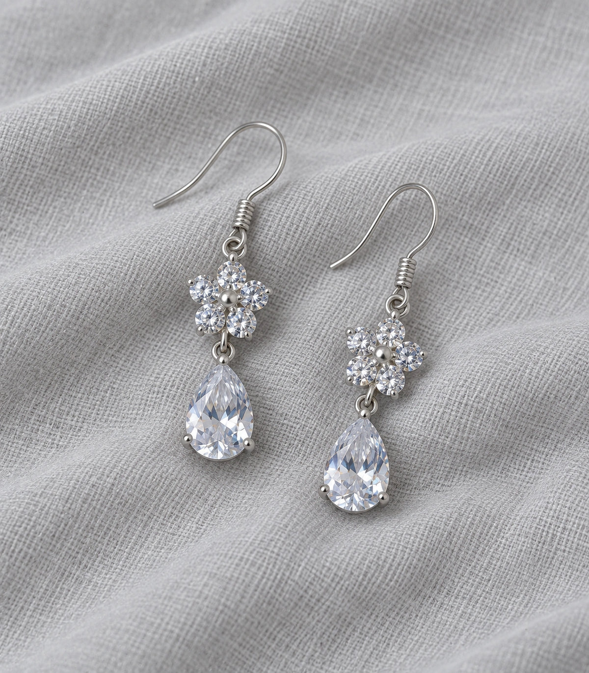 JIMIKI Silver-Tone Round Crystal Flower Pear Drop Earrings in Silver Tone, editorial flat lay