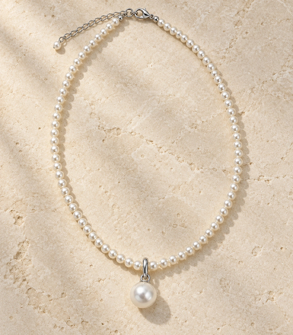 JIMIKI Silver Tone Round Pearl Drop Beaded Necklace in Silver tone / white, editorial flat lay
