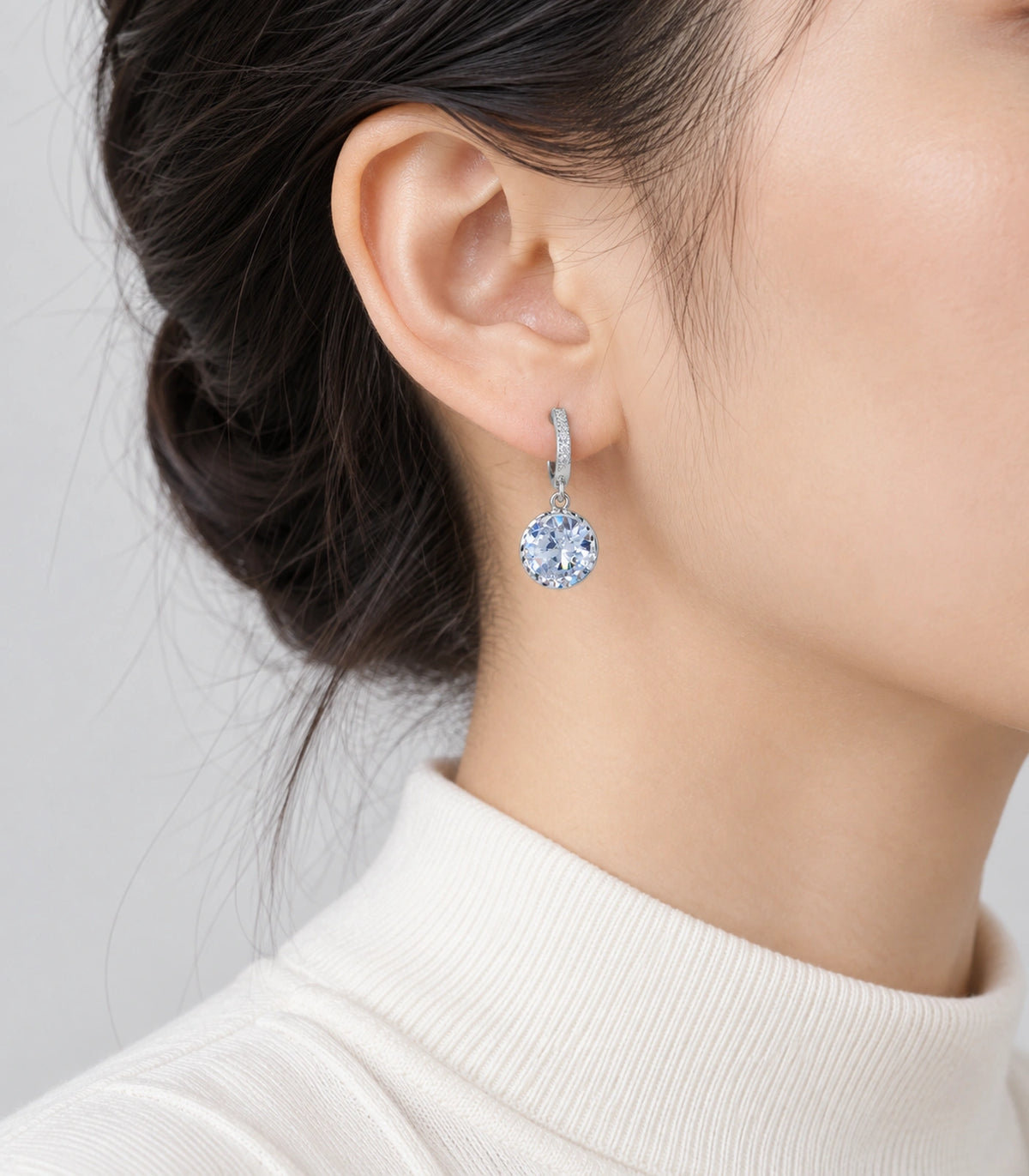 JIMIKI Silver-Tone Round Solitaire Drop Huggie Earrings in Silver / Clear, model wearing view