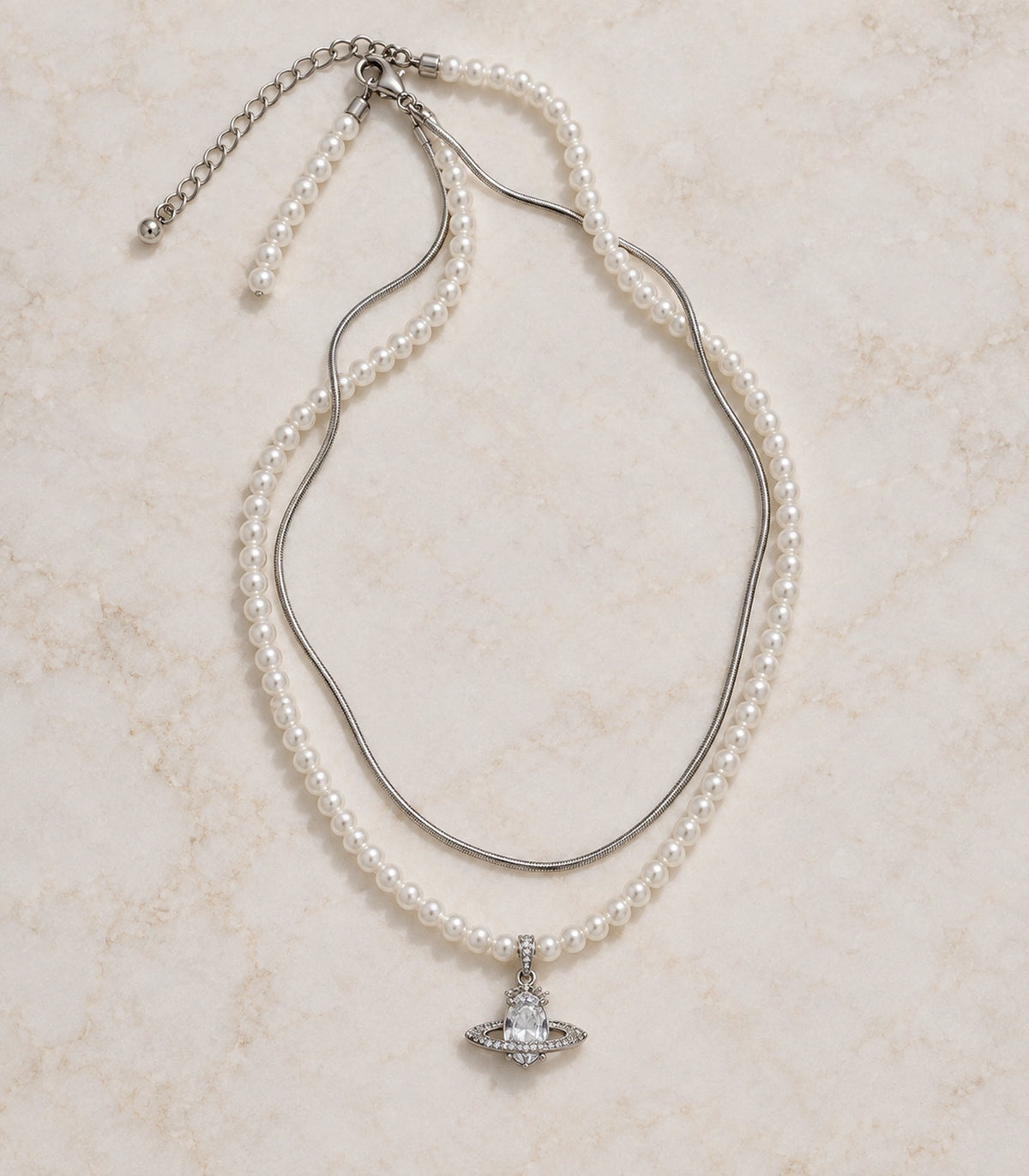 JIMIKI Silver-Tone Saturn Layered Pearl Necklace Set in Silver-tone / clear / white, arranged in an editorial flat lay