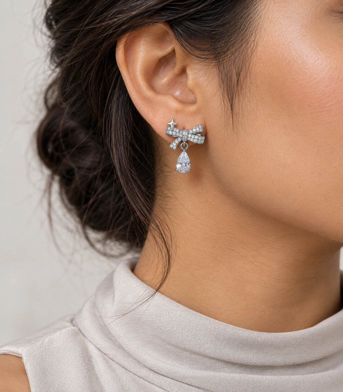 JIMIKI Silver-Tone Star Bow Pear-Drop Earrings in Silver / Clear, model wearing view