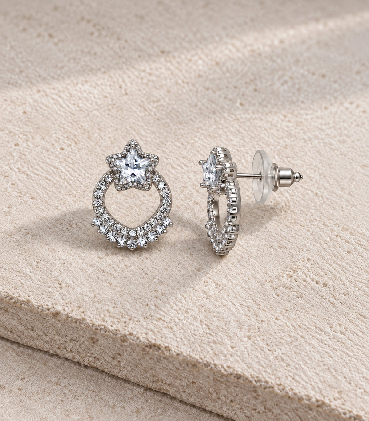 JIMIKI Star Crystal Open Loop Stud Earring Pair in Silver Tone, editorial flat lay #color_silver tone