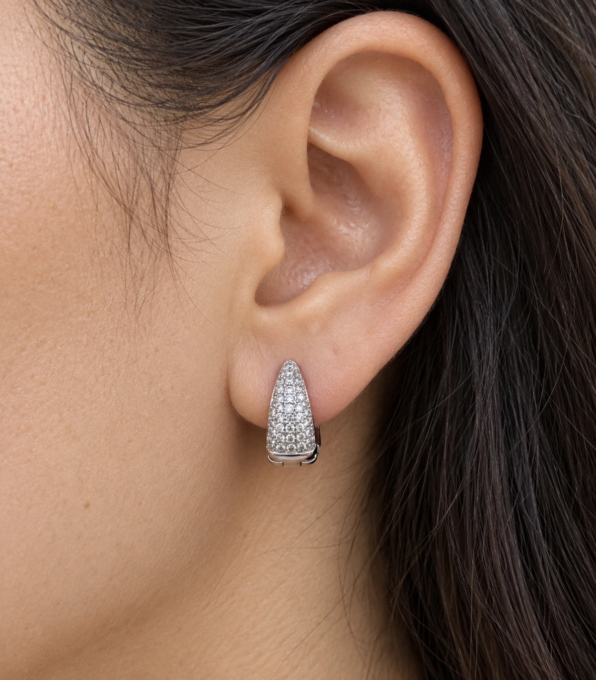 JIMIKI Silver tapered pave huggie hoop earrings, worn closeup of the tapered clear pave front #color_silver