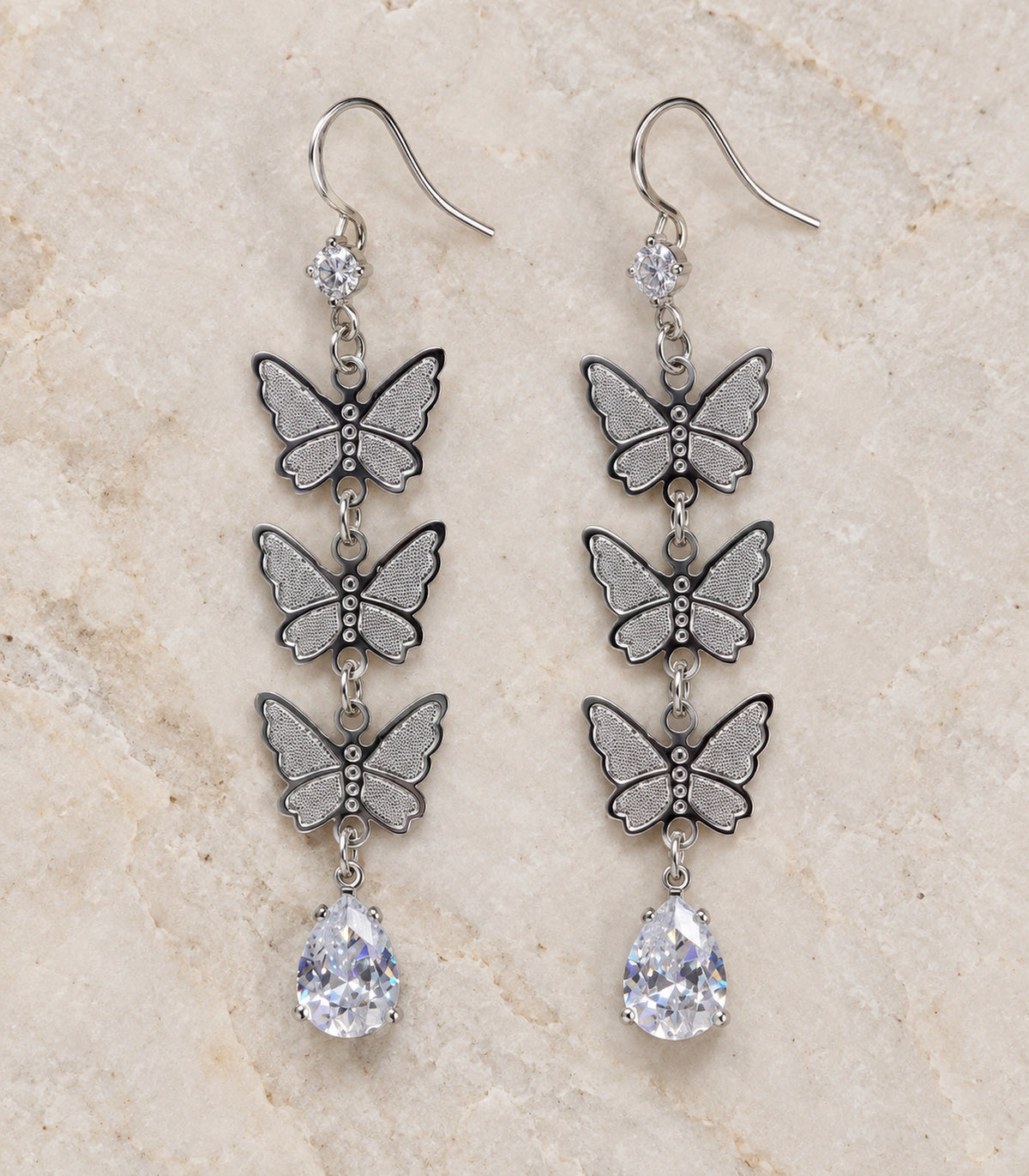 JIMIKI Silver Tone Three Butterfly Pear Drop Earring Pair in Silver-tone, editorial flat lay