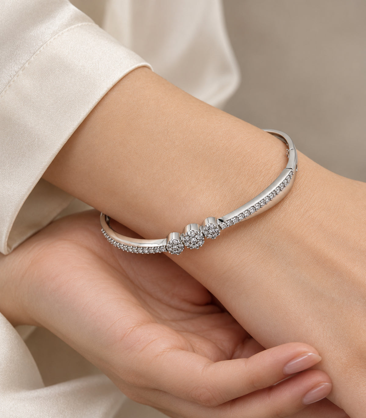 Close view of the silver-tone bangle and three crystal flower clusters on a wrist