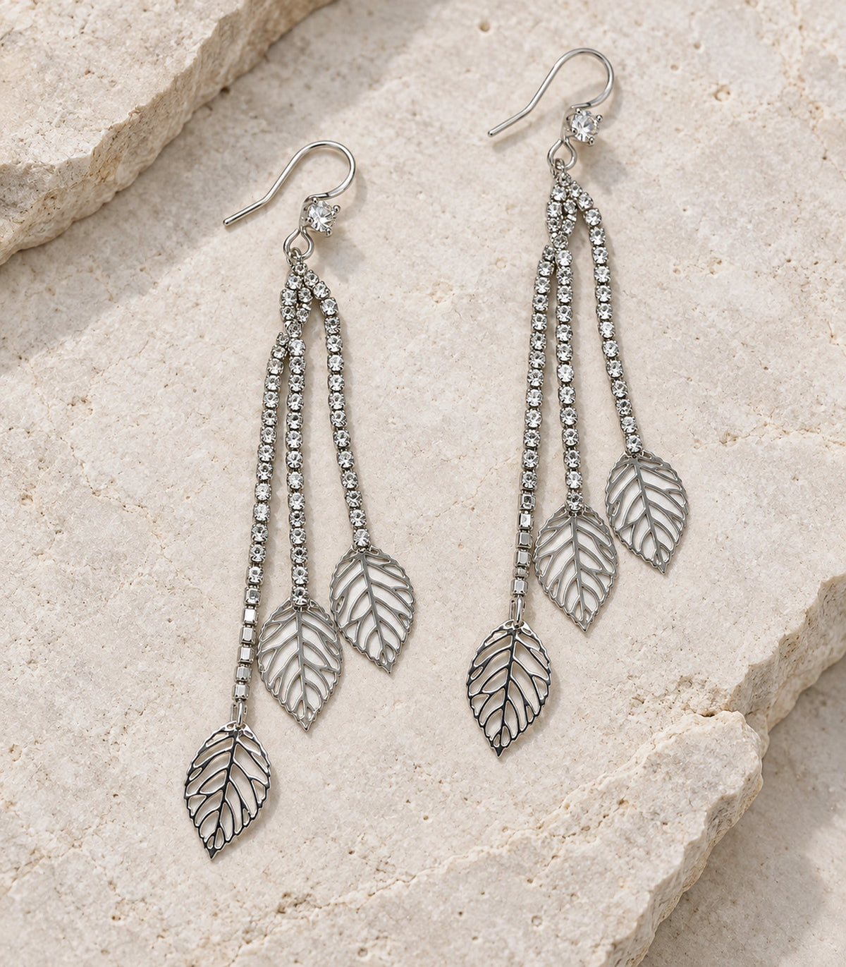 JIMIKI Silver Tone Three Leaf Crystal Tassel Earring Pair in Silver-tone, editorial flat lay