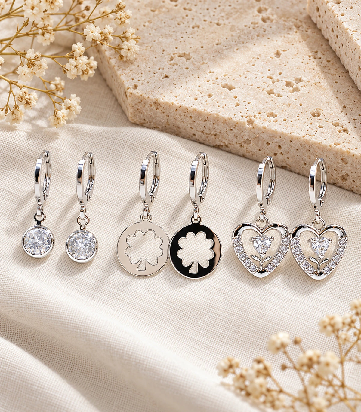 Silver-tone three-pair hoop earring set editorial flat lay