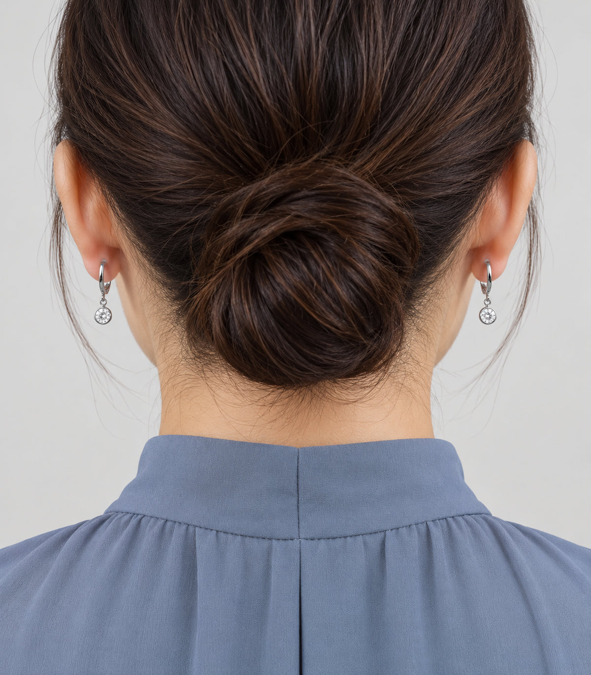 Silver-tone hoop earrings from the three-pair set shown worn
