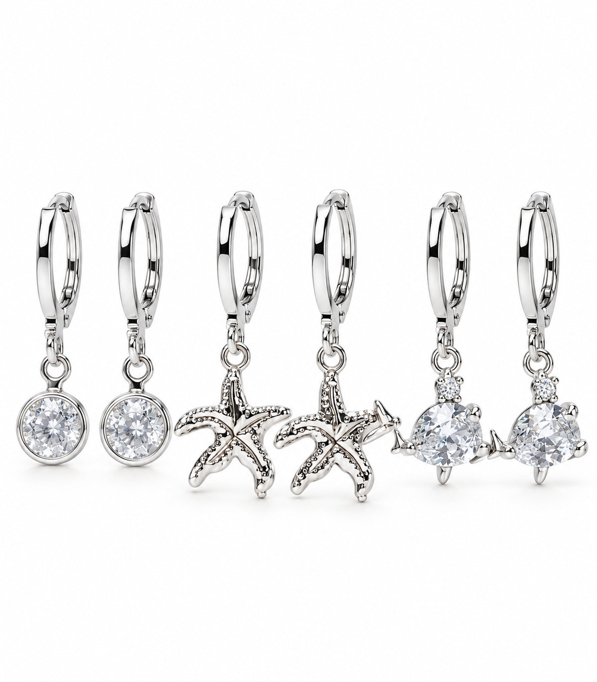 Complete six-earring silver-tone set: round clear crystal, textured starfish and clear fish charm hoop pairs on white.