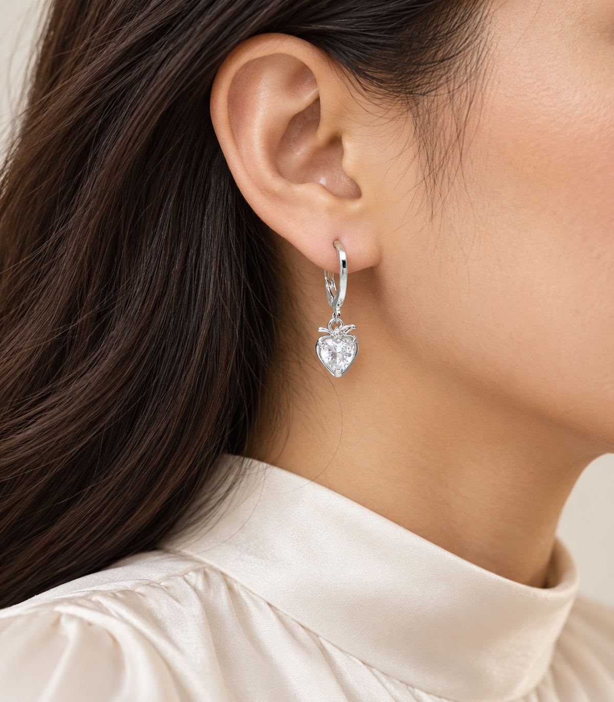 Editorial worn view of silver-tone hoop earrings from the three-pair set