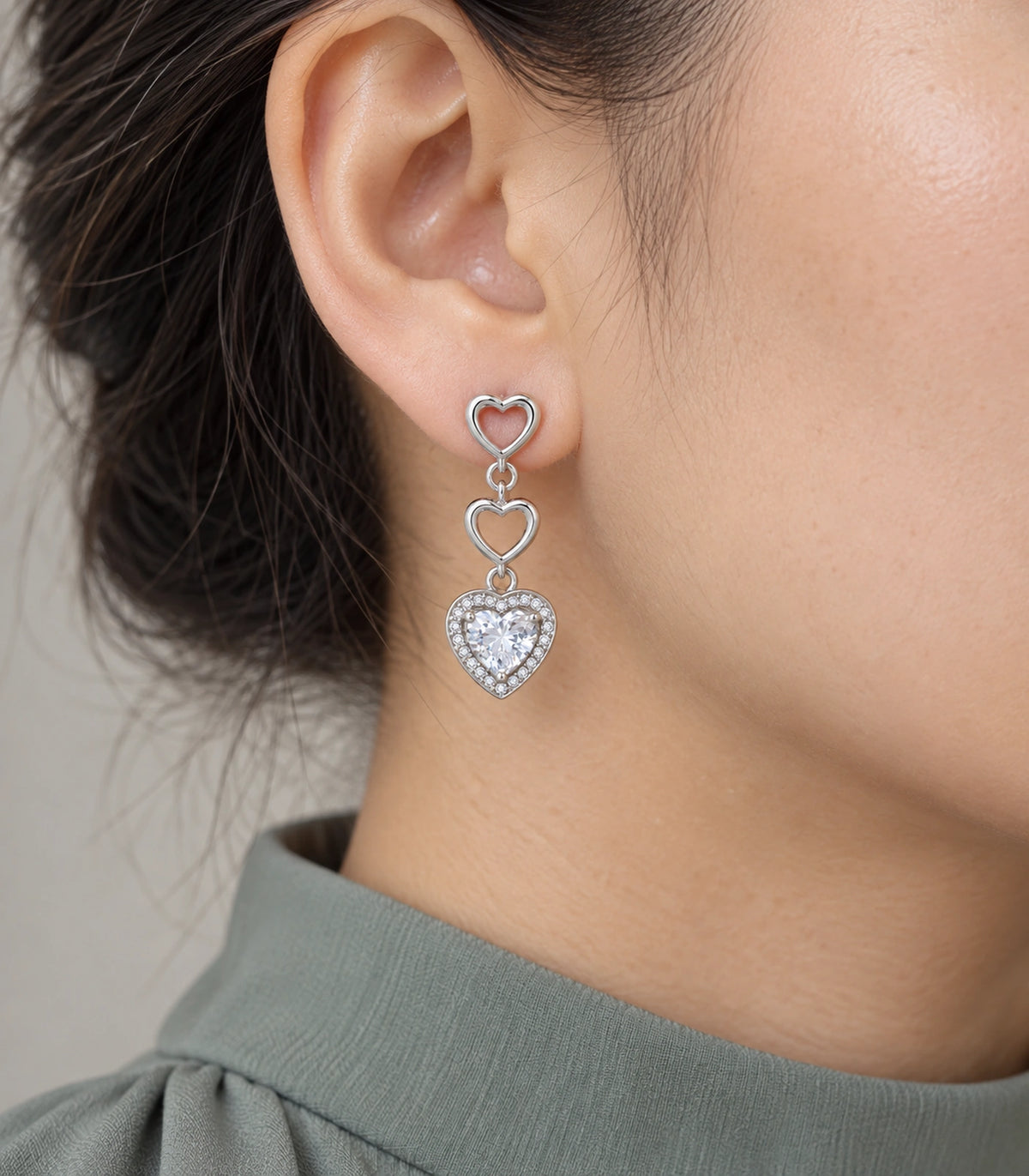 JIMIKI Triple Heart Crystal Drop Earring Pair in Silver tone / clear, close-up detail #color_silver tone / clear
