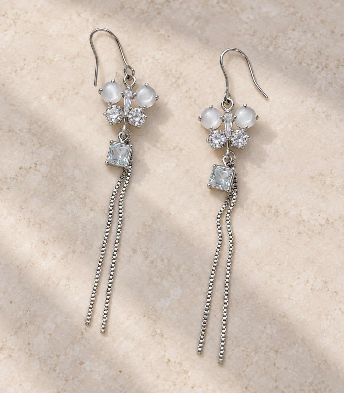 JIMIKI Silver Tone White Butterfly Square Chain Tassel Earring Pair in Silver-tone, editorial flat lay