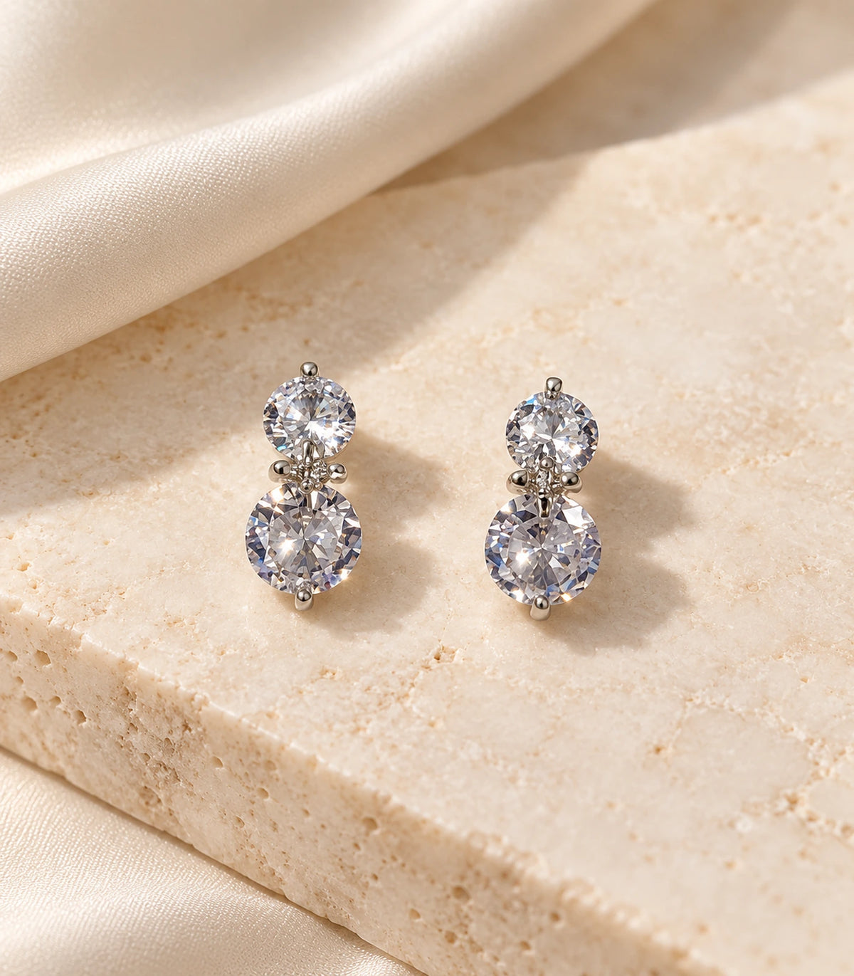 JIMIKI silver-tone two-round crystal drop earrings — editorial-flatlay view