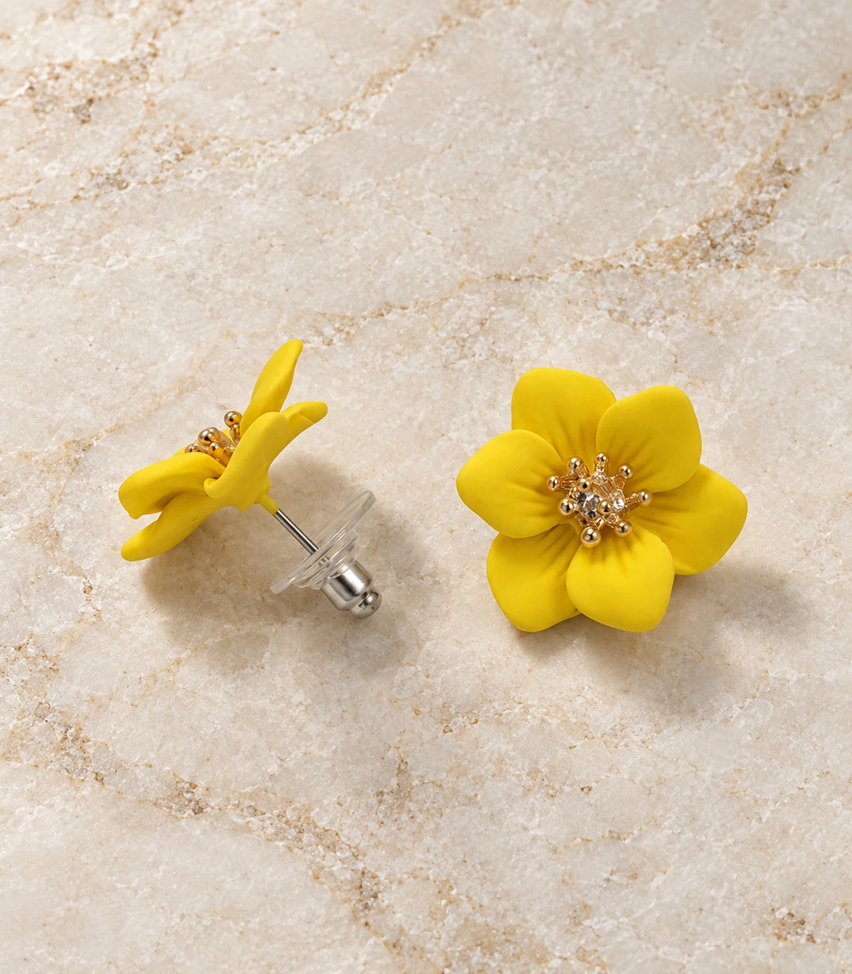 JIMIKI Yellow compact six petal flower stud earrings, matching pair in a styled flat lay #color_yellow