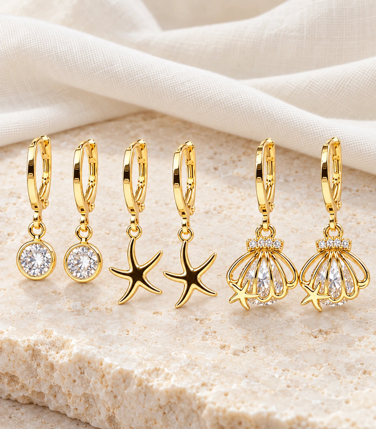 Complete six-earring crystal, starfish and shell hoop set on an editorial surface