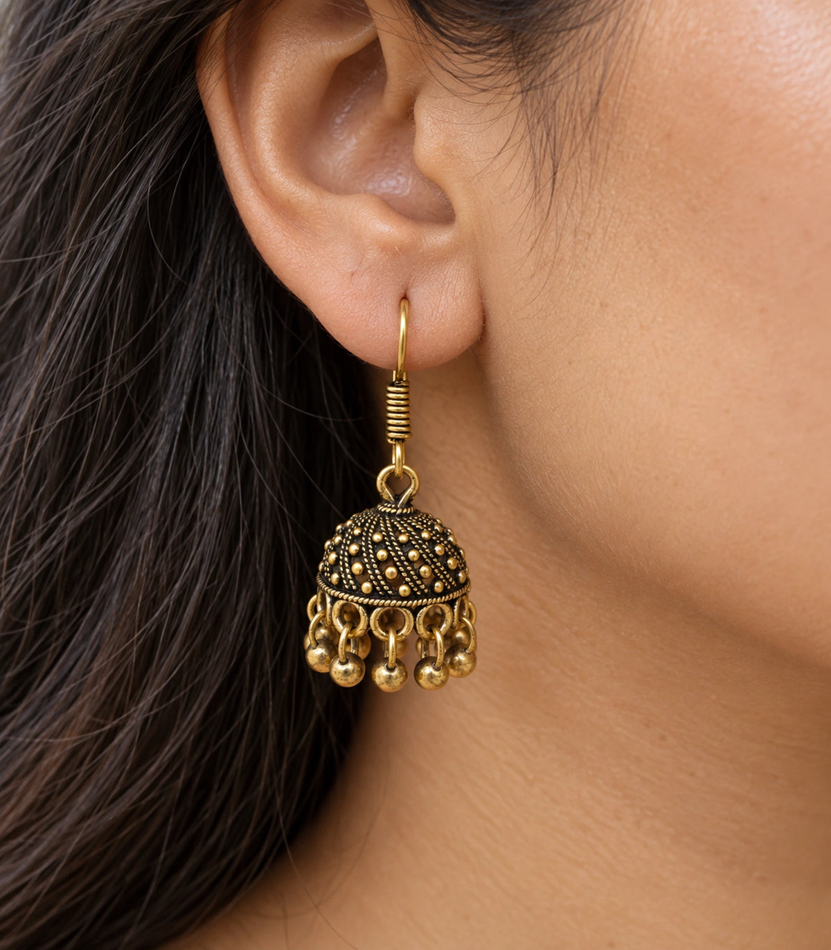 JIMIKI Antique Gold Dotted Swirl Mini Jhumka Earrings - close-up of the earring worn #color_antique-gold