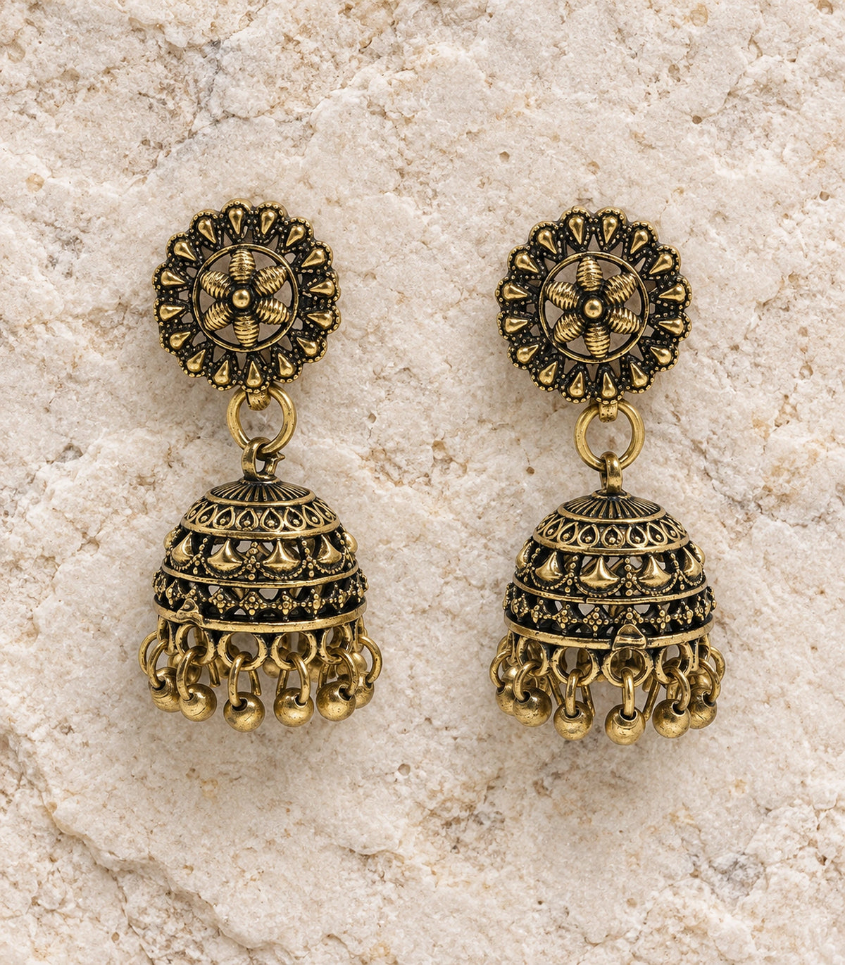JIMIKI Antique Gold Floral Fan Dome Jhumka Earrings - styled flatlay of the matching earrings #color_antique-gold