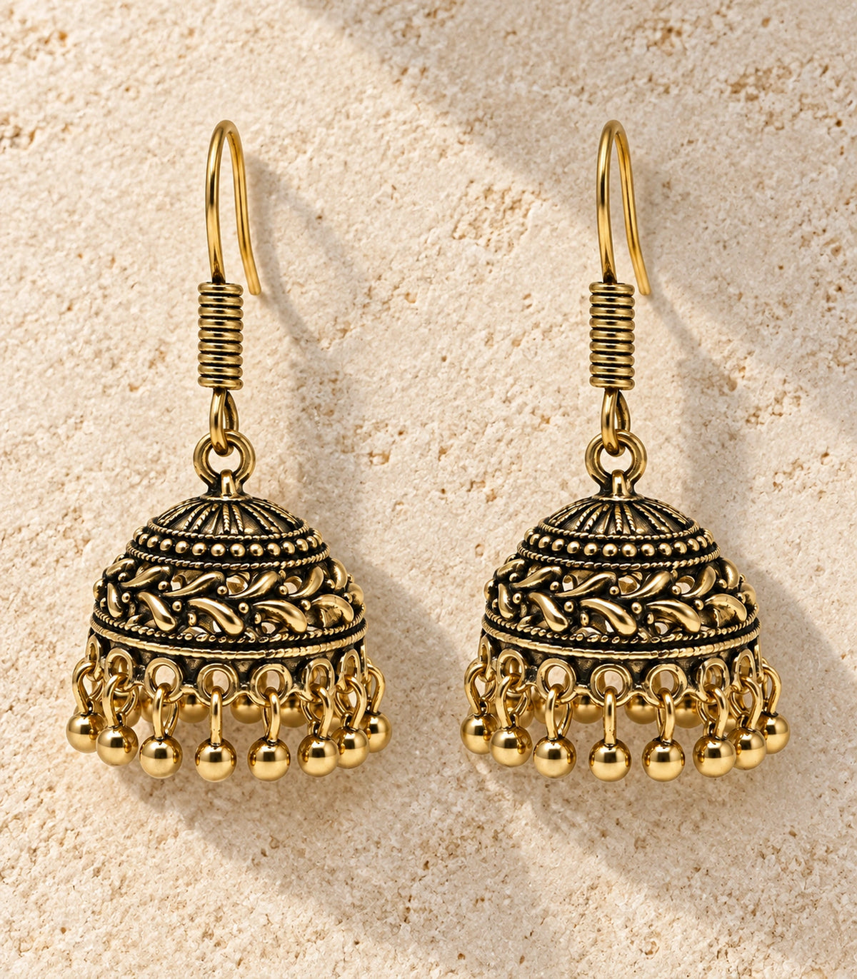 JIMIKI Antique Gold Leaf Scroll Dome Hook Jhumka Earrings - Pair arranged in an editorial flatlay #color_antique-gold