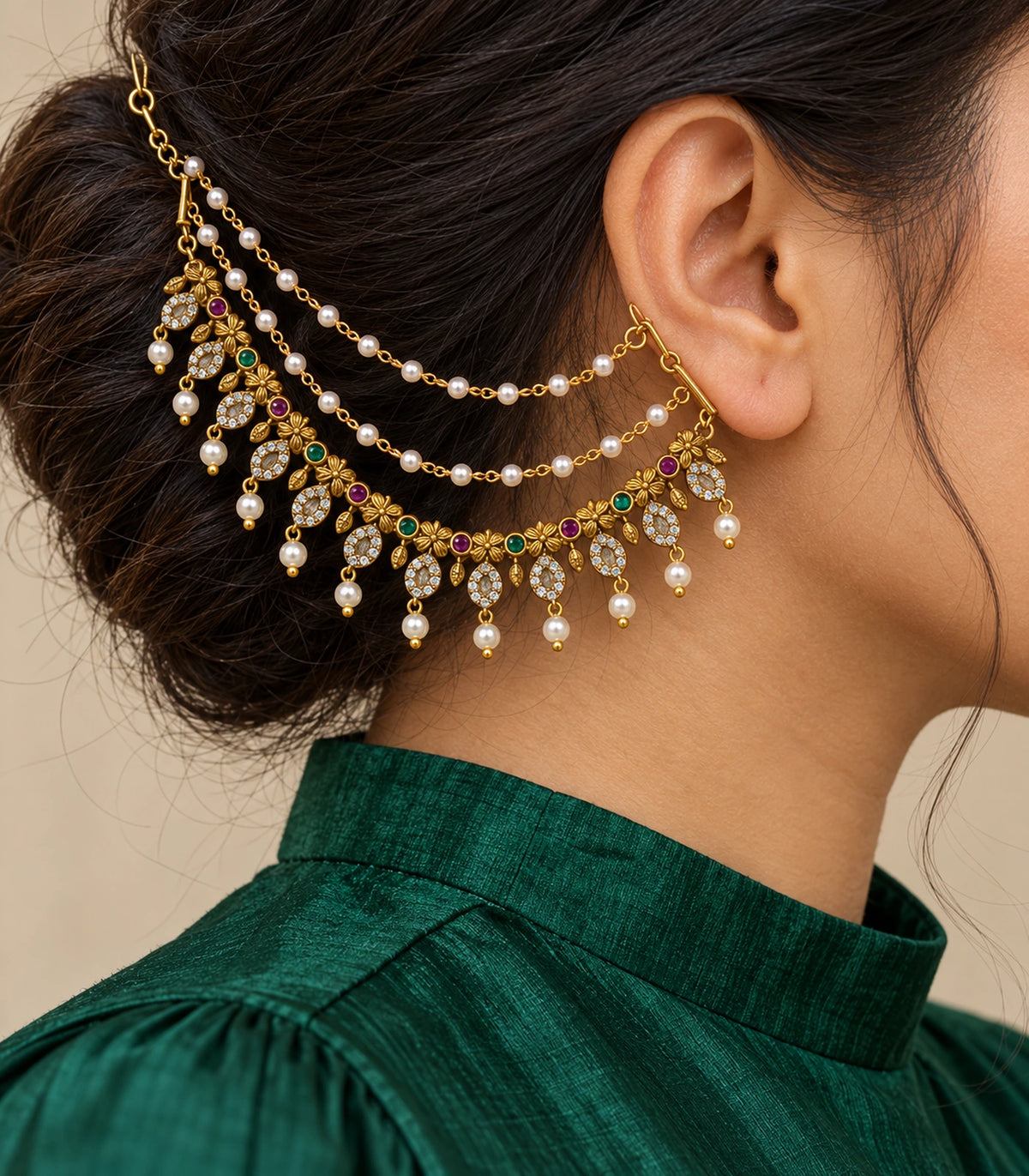 Close view of flower oval pearl ear chain worn with an emerald silk collar