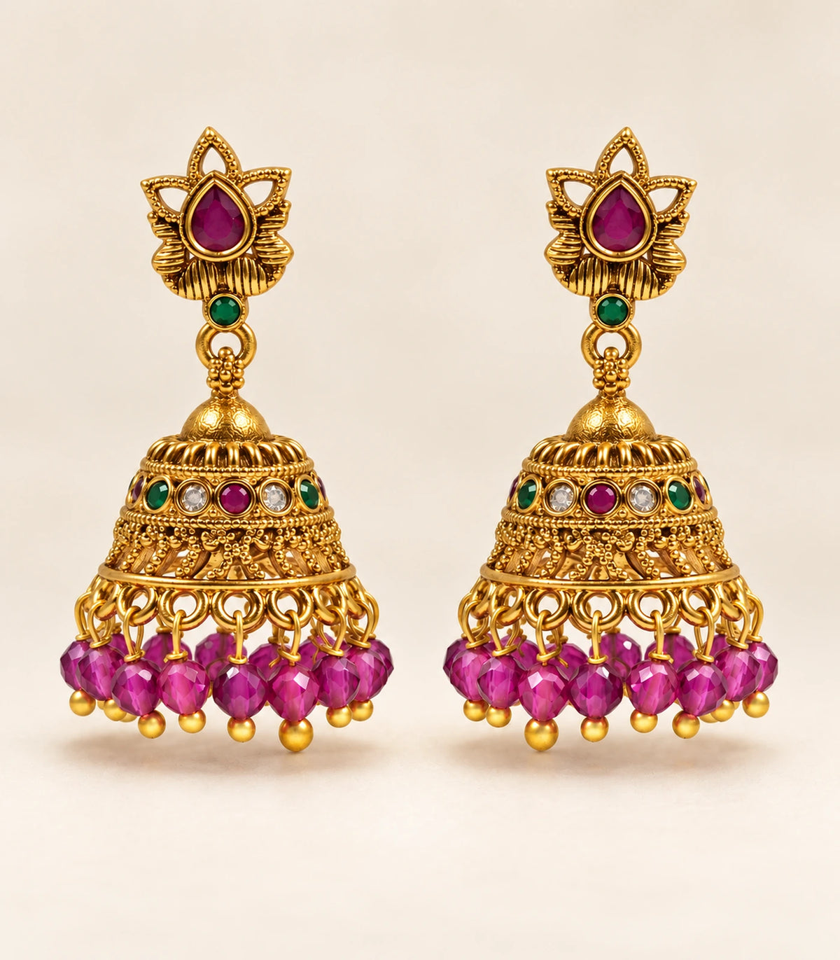 Complete pair of magenta lotus bead jhumka earrings on a cream background