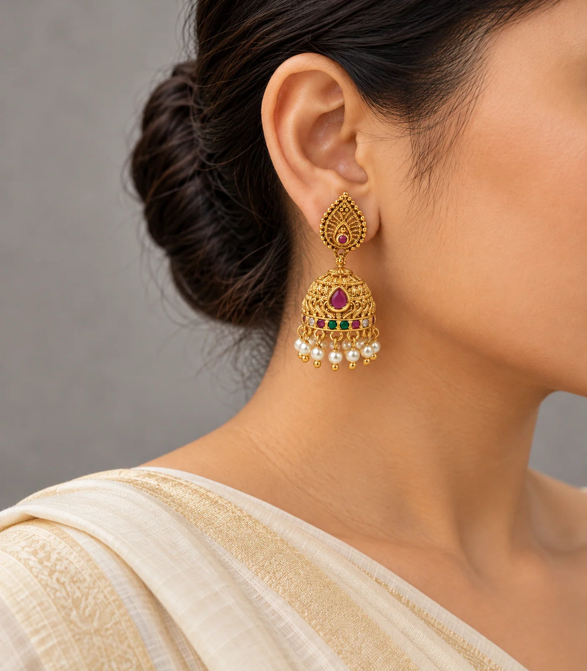 Antique gold magenta multicolour pearl jhumka earrings worn with cream clothing