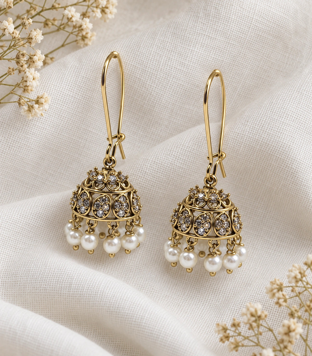JIMIKI Antique Gold Oval Crystal Pearl Kidney Wire Jhumka Earrings - Pair arranged in an editorial flatlay #color_antique-gold