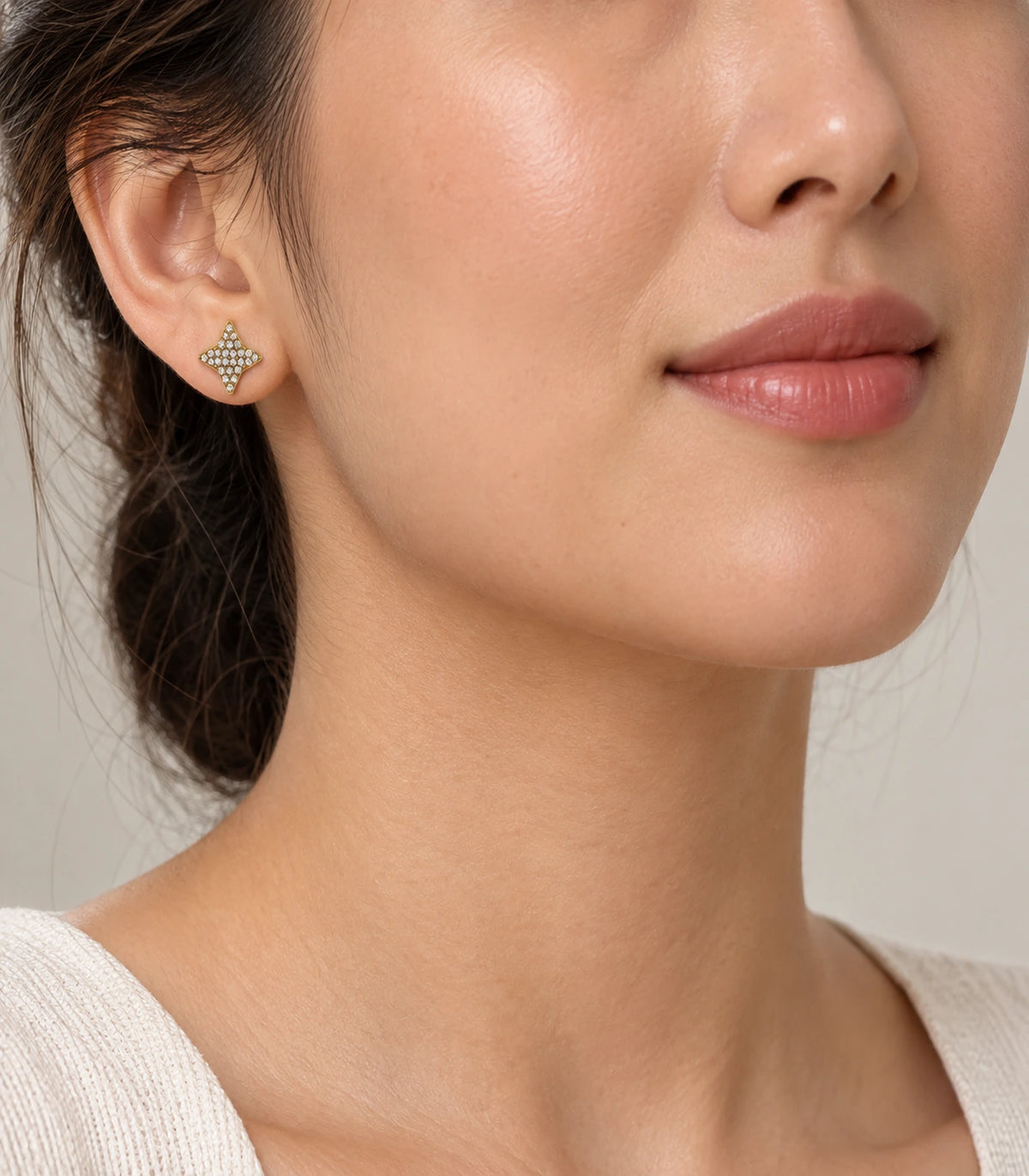 JIMIKI antique gold-tone four-point star stud earrings, stud worn on an earlobe with swept-back hair #color_antique-gold