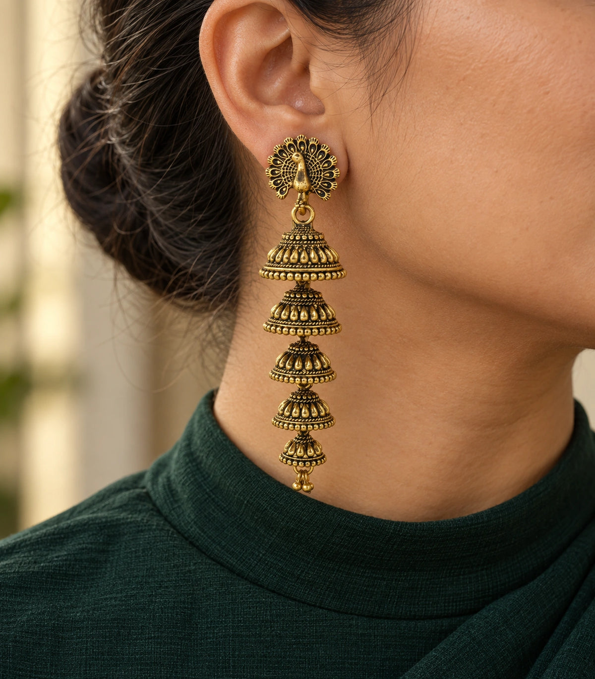 JIMIKI Peacock Five Tier Jhumka Earrings in Antique Gold - editorial worn view #color_antique-gold