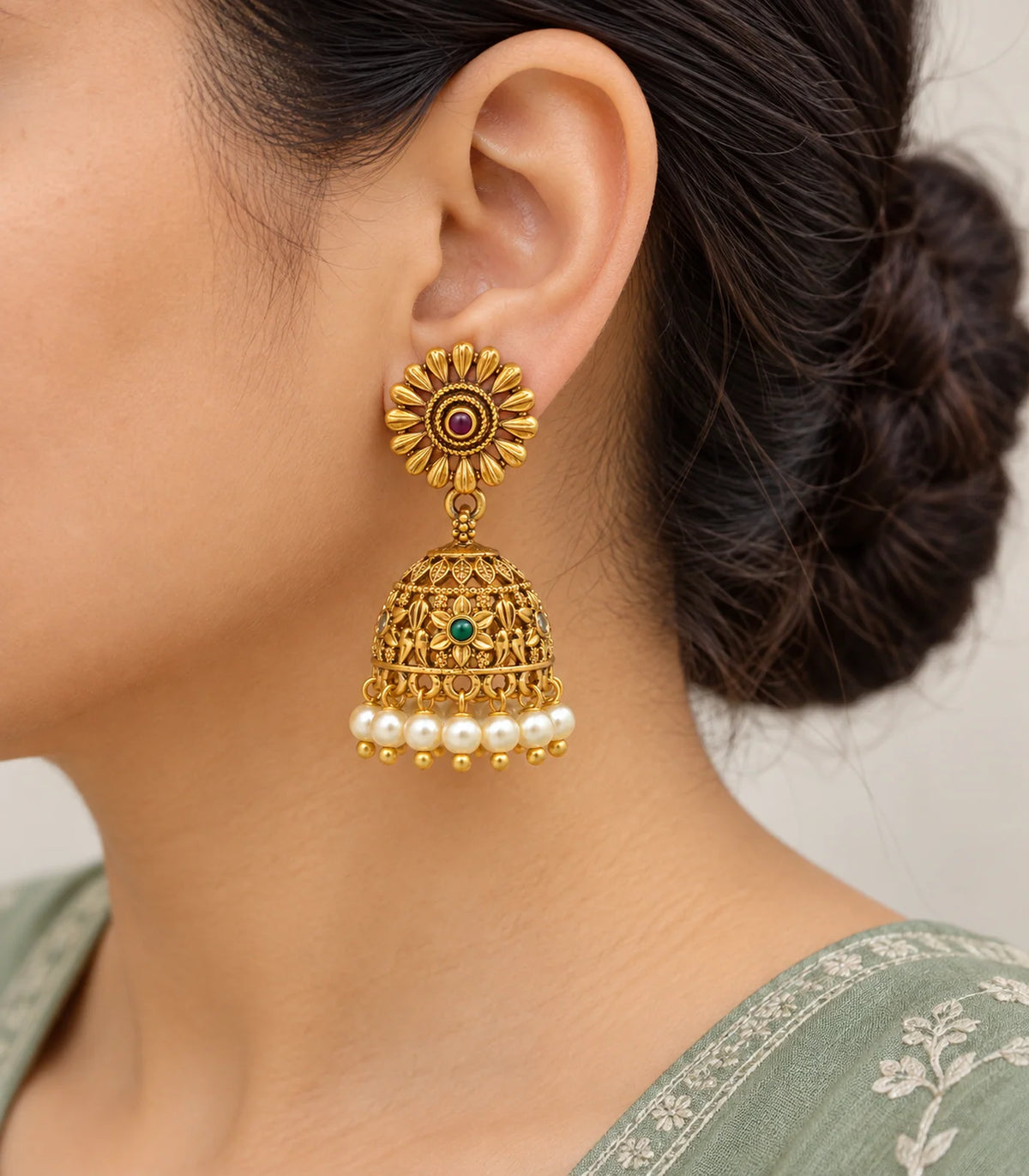 Worn close view of sunflower studs, magenta centres, gold tone open floral bells, green accents and cream pearl fringe