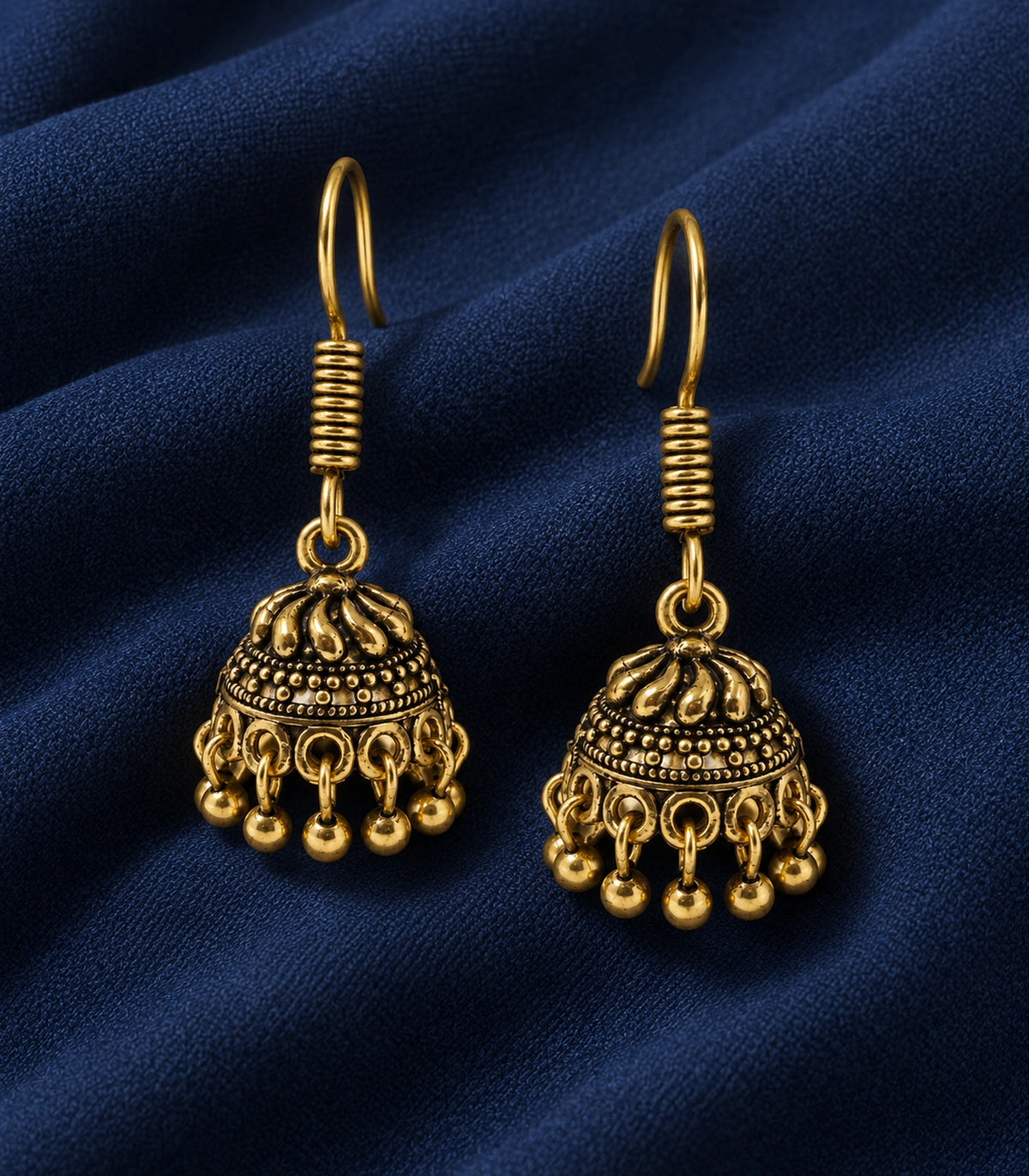 JIMIKI Antique Gold Swirl Crown Jhumka Earrings - styled flatlay of the matching earrings #color_antique-gold